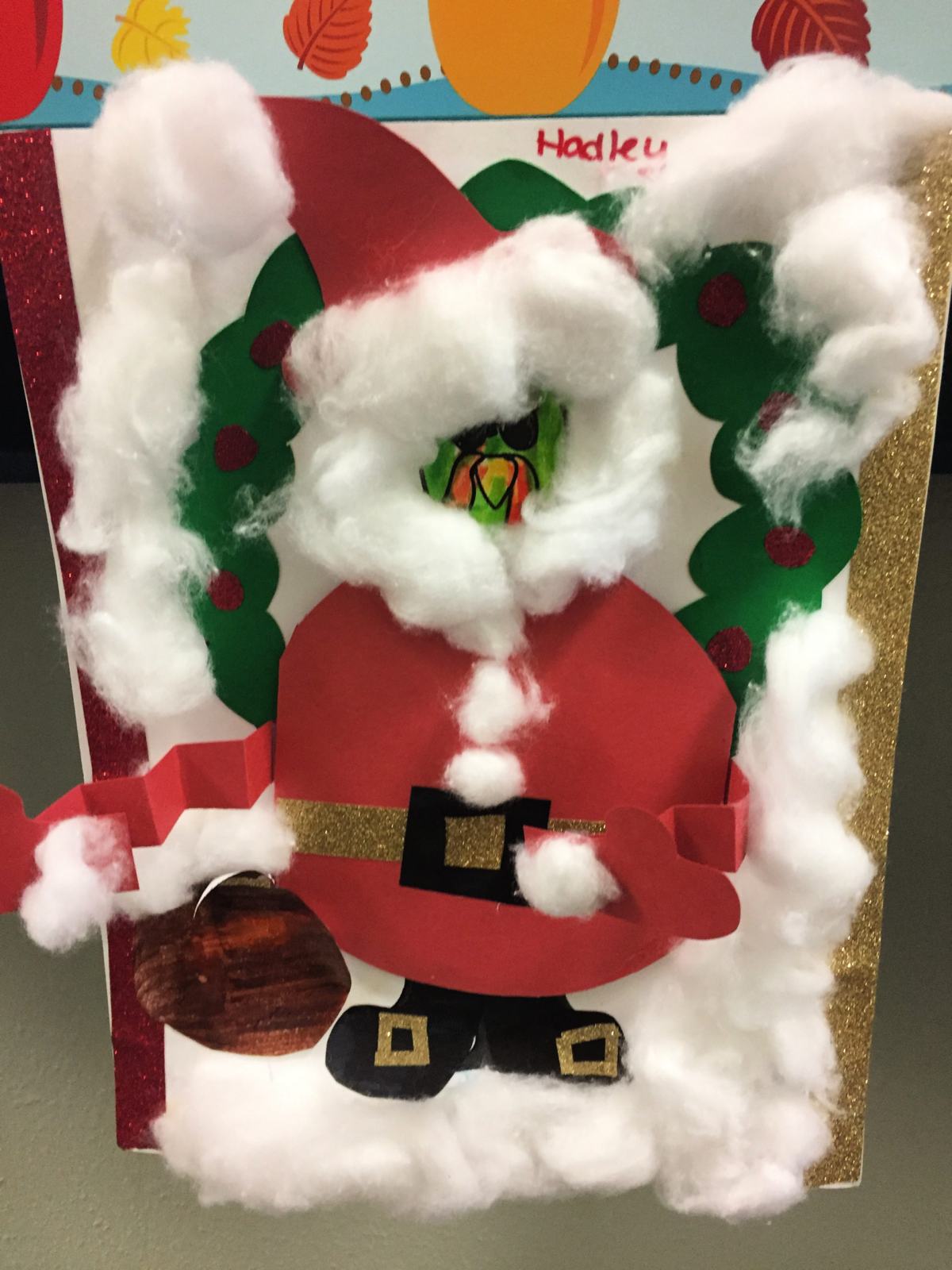 Paper Turkey In Disguise dressed as Santa Claus with red construction paper outfit with cotton balls around for snow and beard.