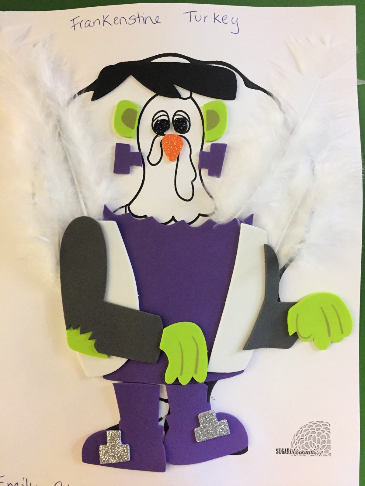 Paper Turkey In Disguise dressed as Frankenstein with foam clothing, and white feathers in the back.