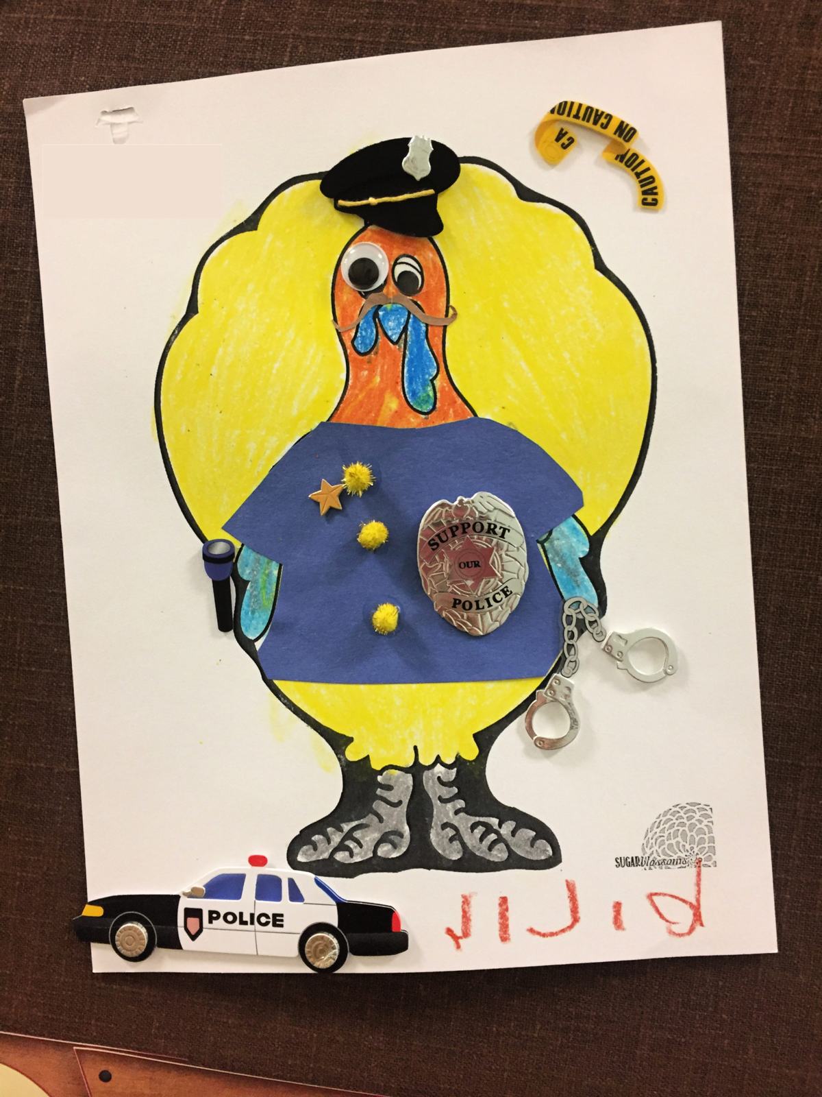 Colored paper of a Turkey In Disguise Police Officer with real police badge.