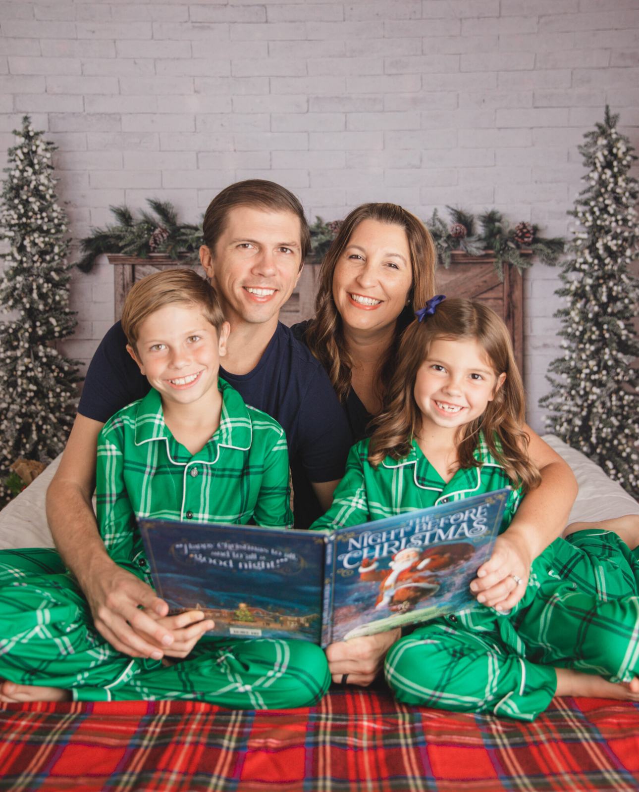 Family in matching pajamas reading the night before christmas.