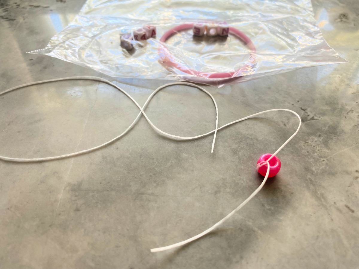 Bead tied on elastic necklace on a countertop.