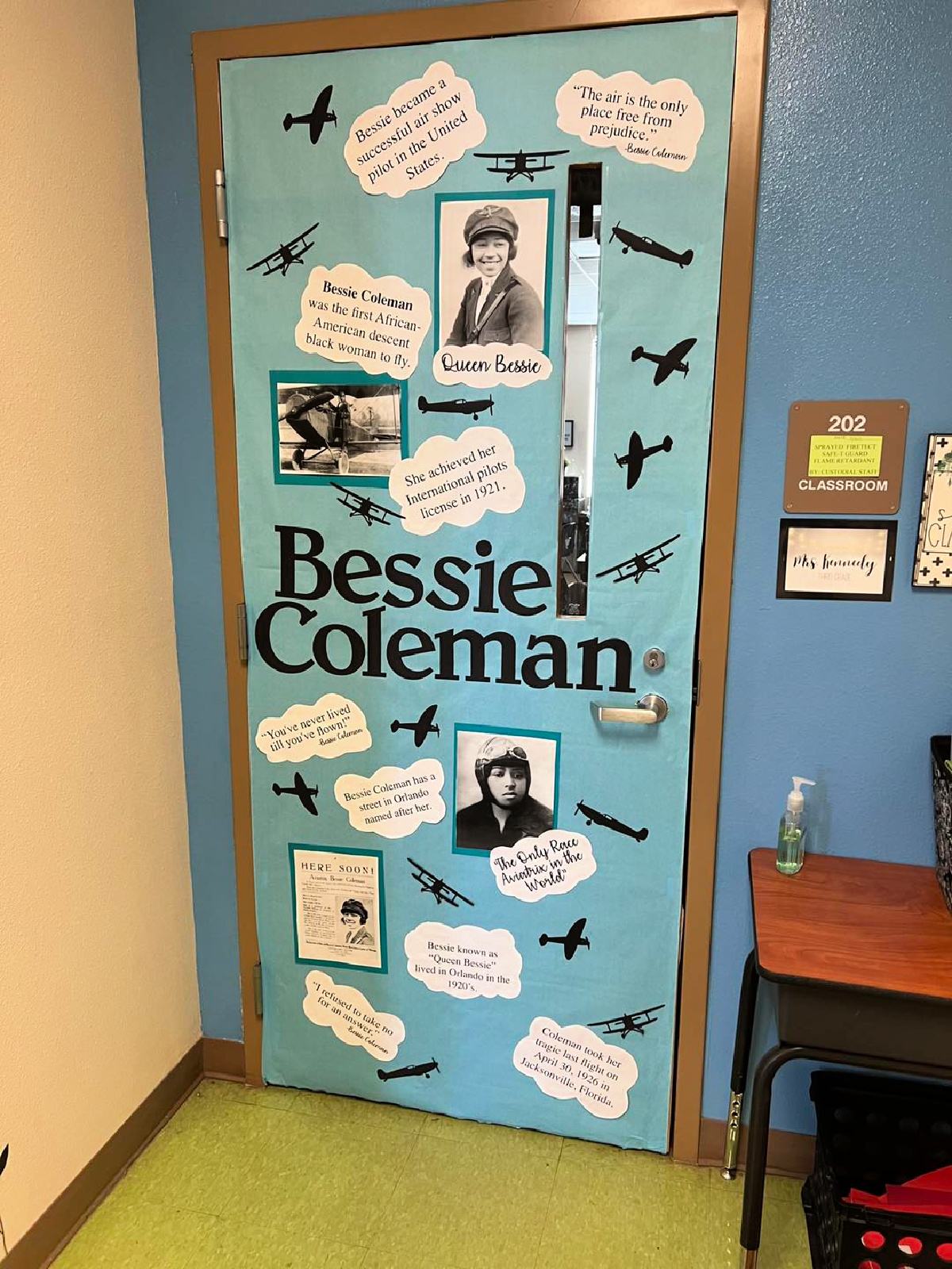 Blue door with airplanes and the name "Bessie Coleman" and clouds with quotes and facts about her.