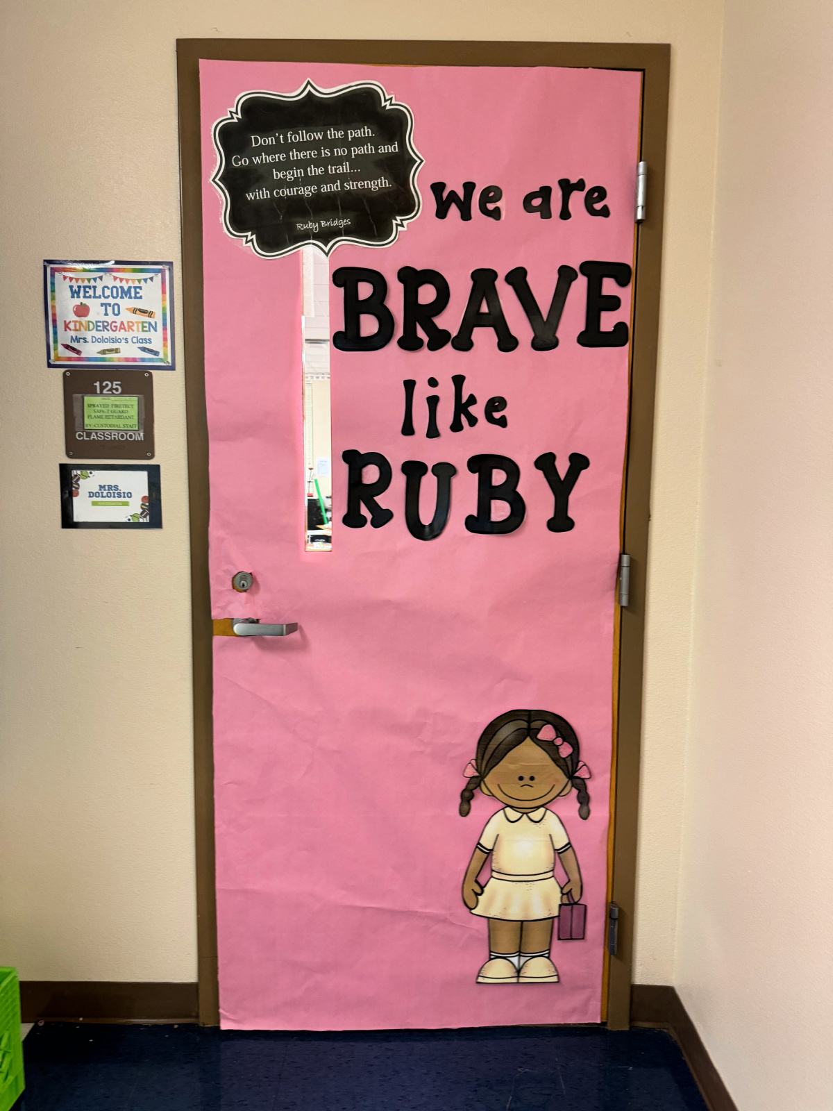 Pink door with "we are brave like Ruby" and a little black girl on door.