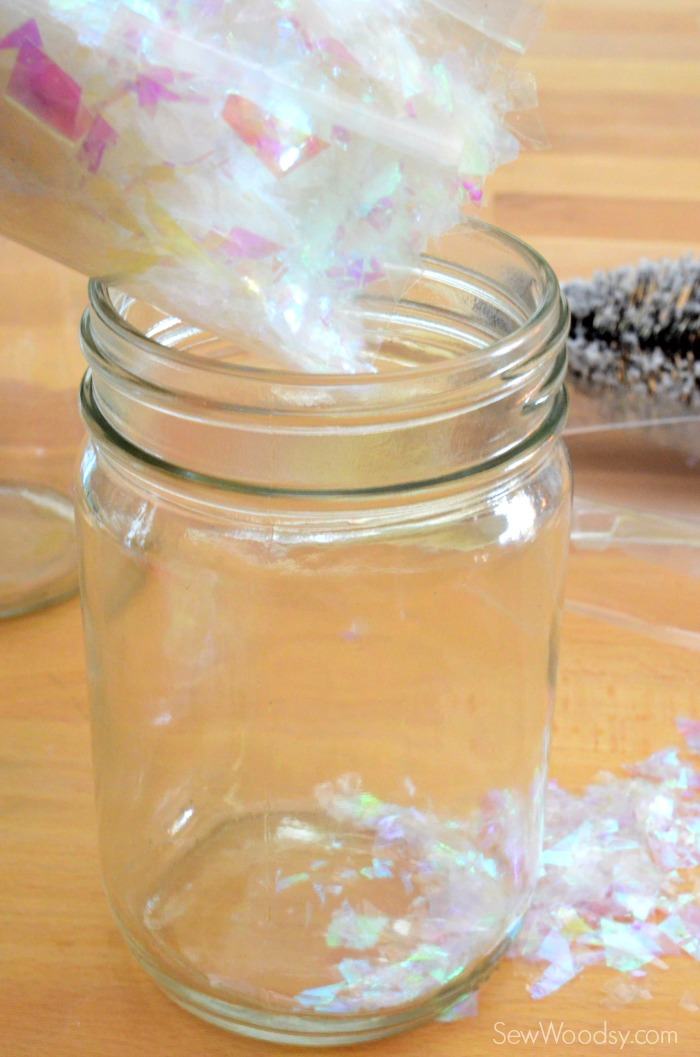 Bag of fake snow being poured into a mason jar.
