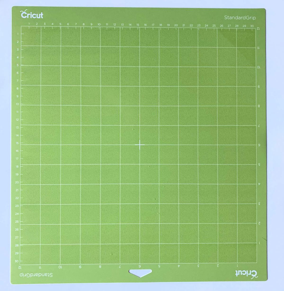 Neon green Cricut StandardGrip Mat on a white surface.