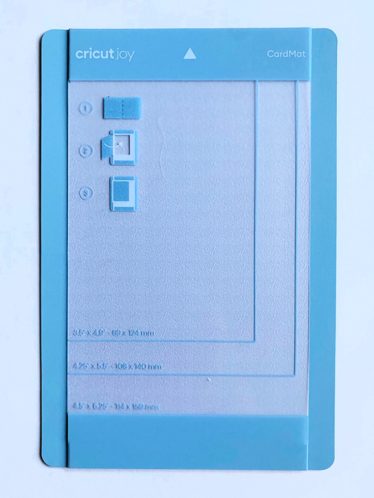 Small light blue Cricut Joy CardMat on a white surface.