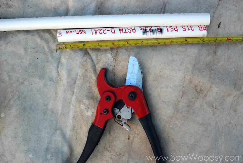 PVC cutters, PVC, and tape measure on a tan drop cloth.