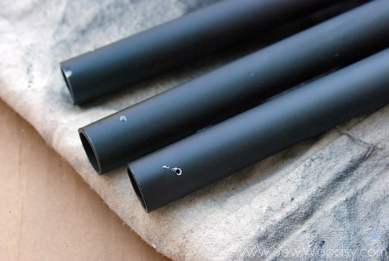 Three black poles with holes drilled in them.