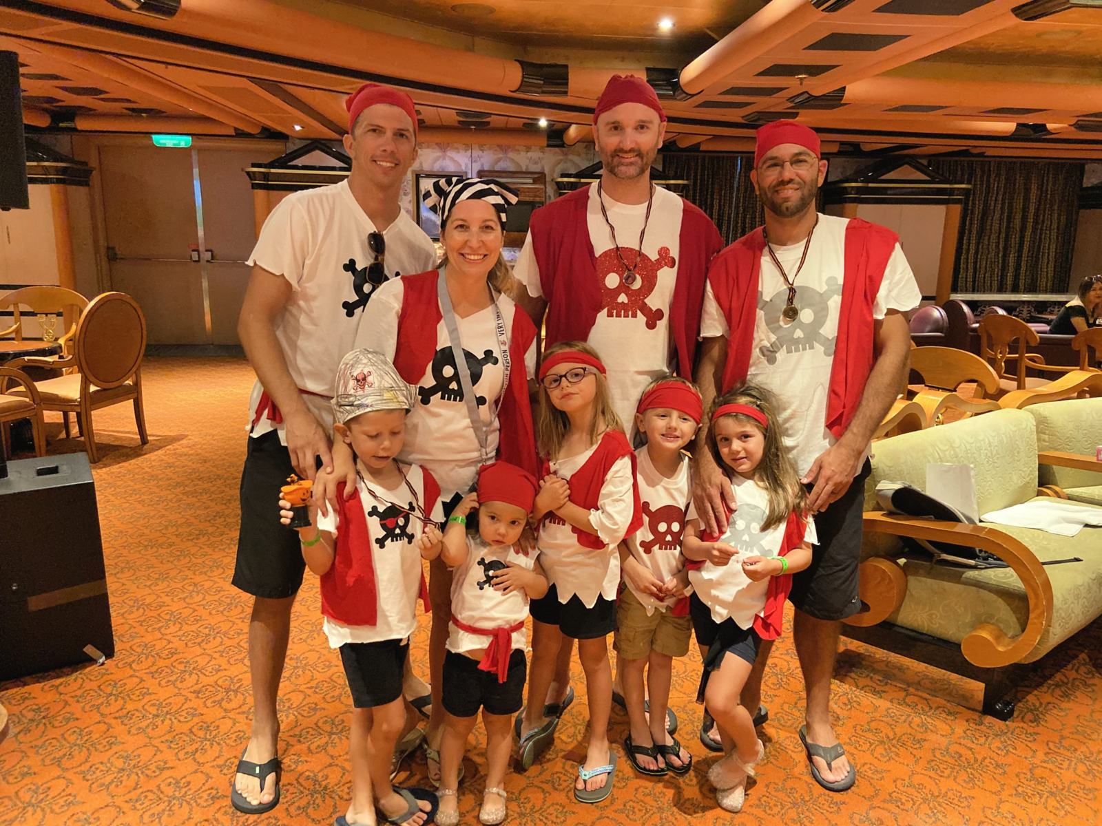 Men and women with children all dressed in a pirate shirt.