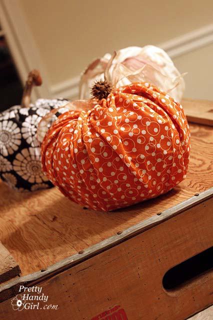 Orange cloth pumpkin on a wood crate.