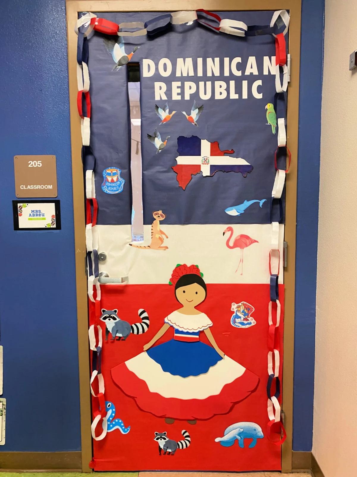 Blue, white, and red classroom door with a female and paper chains and the words Dominican Republic on the door.