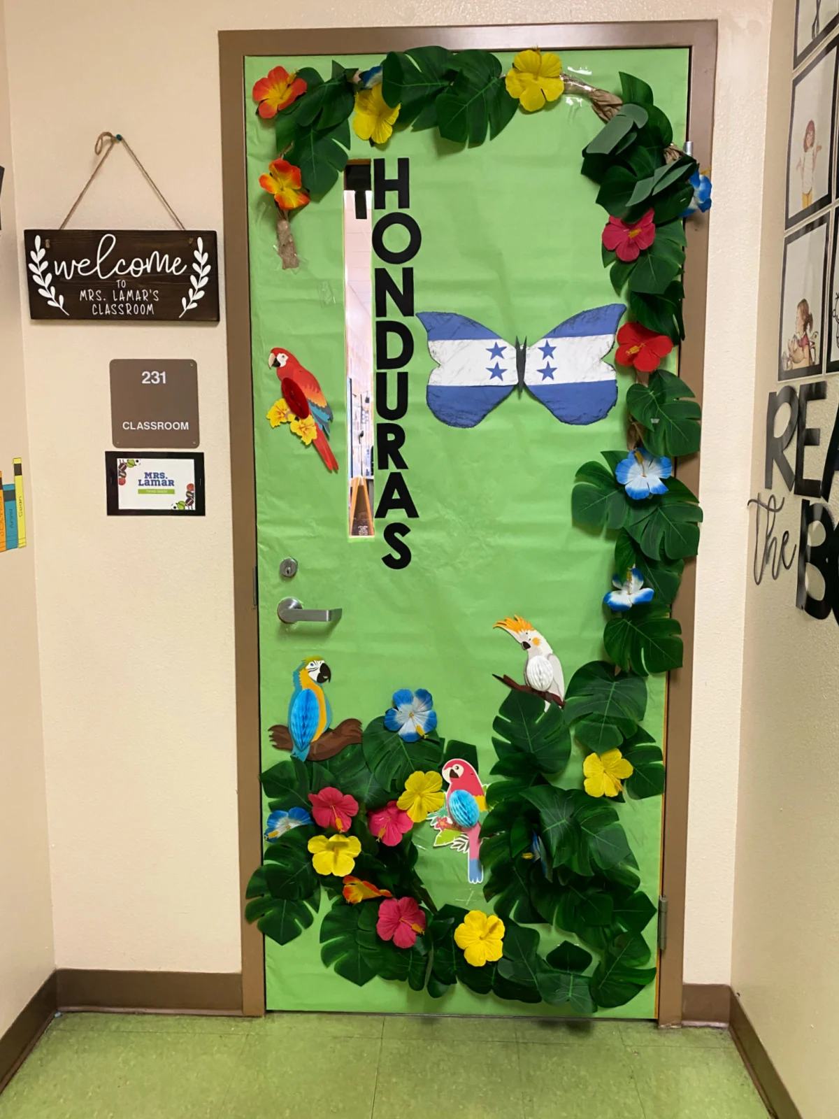 Green classroom door with leaves, flowers, and birds with the words "Honduras" on the door.