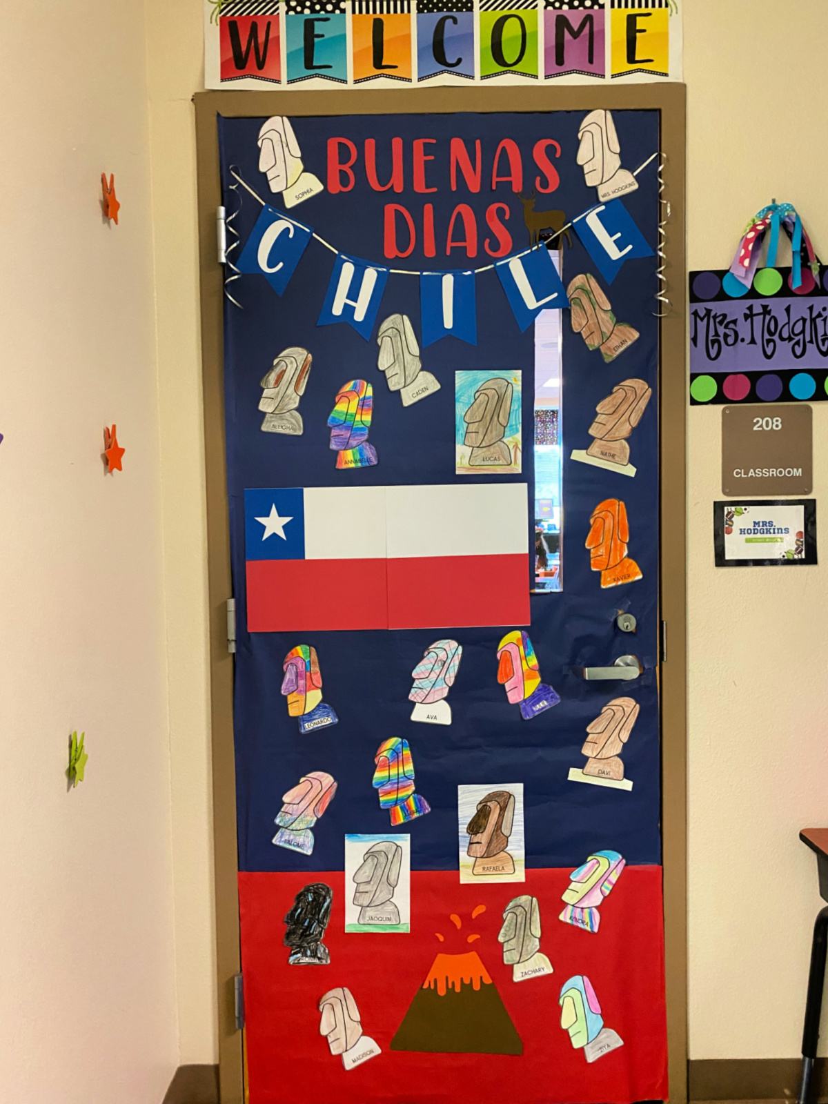 Blue and red door that says Buenas Dias Chile with colored stone heads.