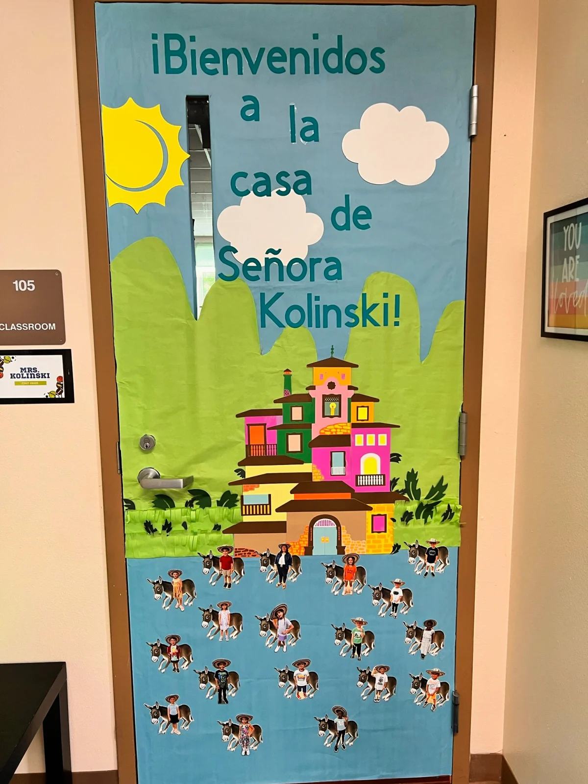 Blue classroom door that has a cassita with the words "Bienenidos a la casa de Senora Kolinski!".