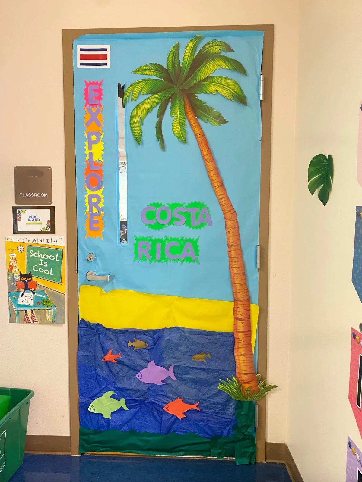 Blue classroom door with a palm tree and the ocean with the words "Costa Rica"