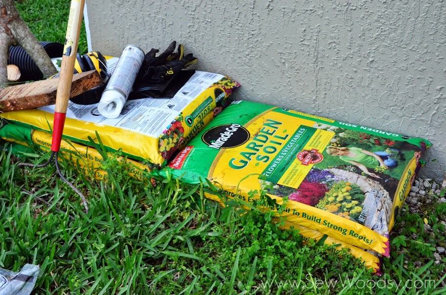 Bags of Garden soil and supplies on grass.
