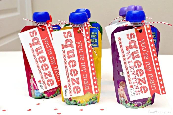 Seven pouches with bakers twine and valentines attached to them.