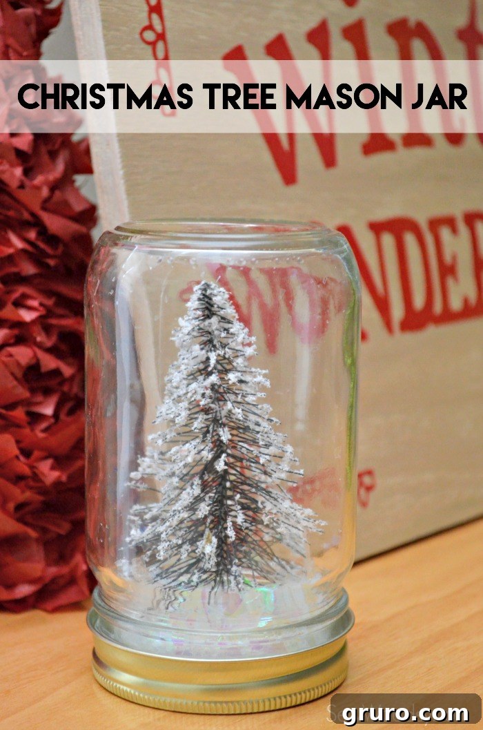Glass mason jar filled with fake snow and a wire bottle brush tree with text on image for Pinterest. A perfect DIY Christmas decor project.