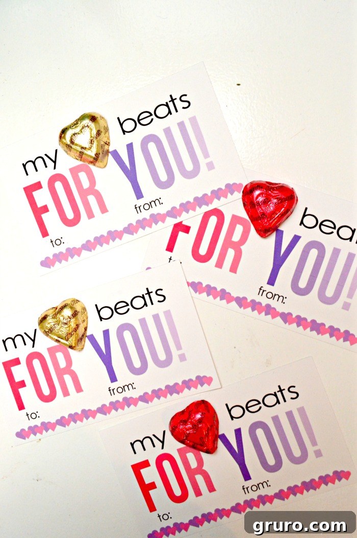 Pitter-Patter Valentine: Classroom Edition 11 Four Valentine cards artfully arranged on a white desk, each adorned with a Reese's Heart candy.