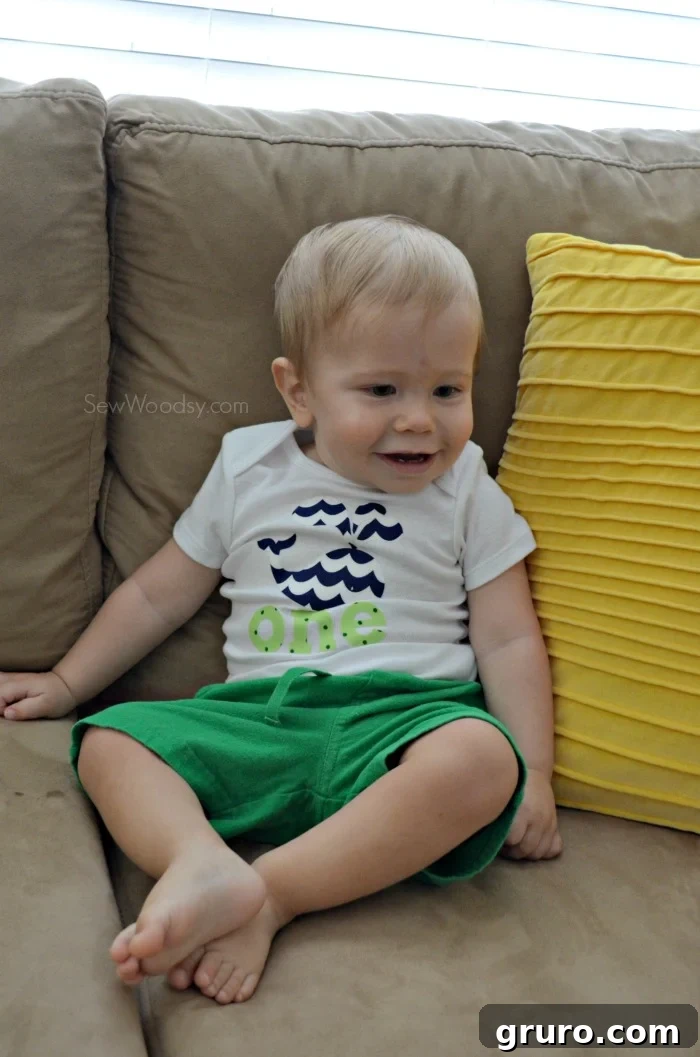Baby Ryder in his custom 'ONE' onesie, looking attentively at the family dog