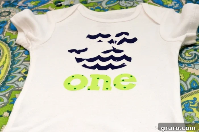 Close-up of the completed DIY custom first birthday onesie with fabric 'ONE' design