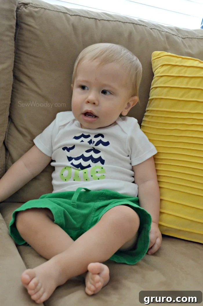 Baby Ryder striking a cute pose in his custom 'ONE' birthday onesie