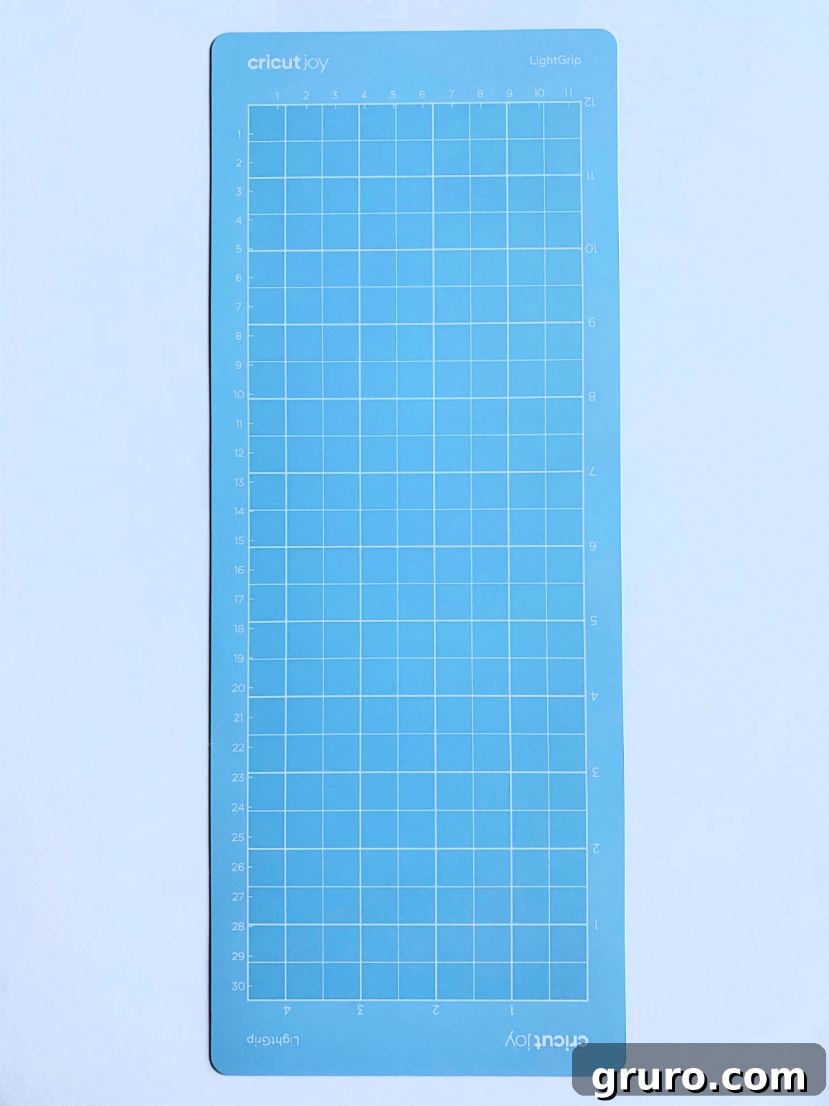 A single, long light blue Cricut Joy LightGrip mat displayed on a white surface, ready for cutting lightweight materials with the compact Cricut Joy machine.