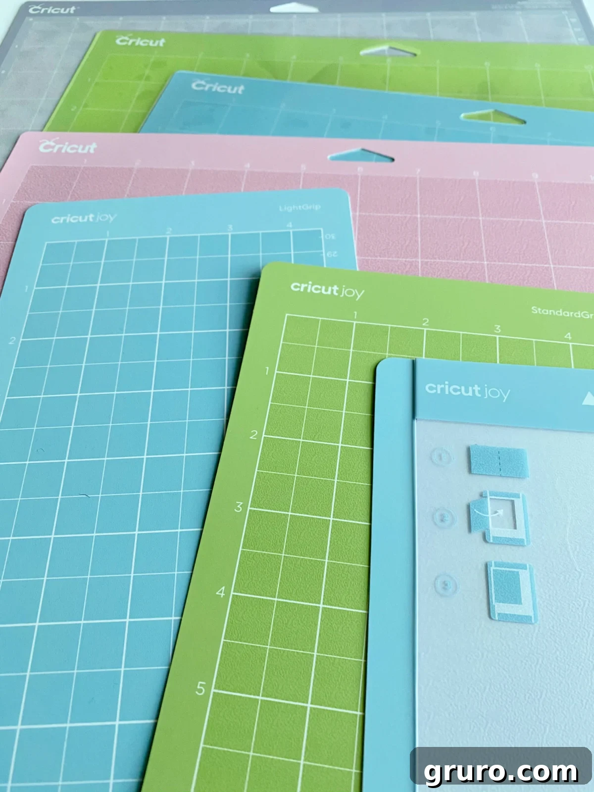 A close-up view of seven distinct Cricut mats, showcasing their varying textures and colors, emphasizing the diverse range available for crafting.