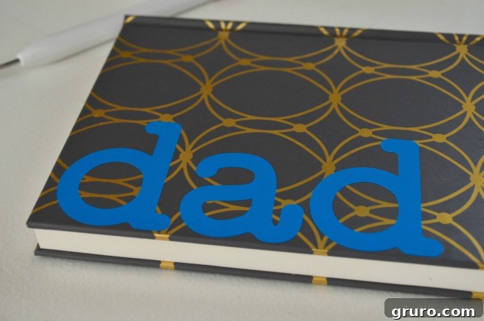 Carefully removing the transfer tape from the finished DIY Father's Day Journal