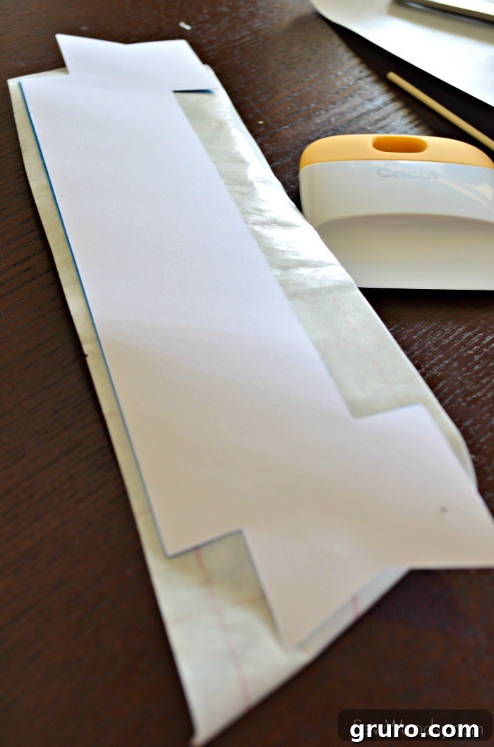 Placing white banner onto sticky vinyl for cake topper