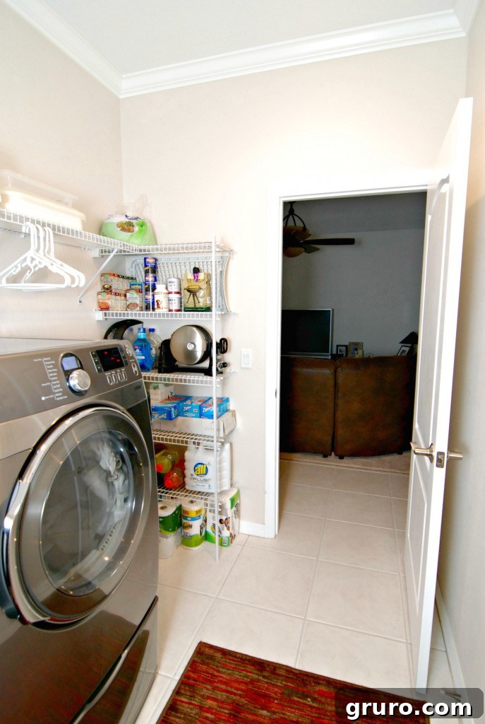 Tidy laundry room offering a partial view into the connected living room