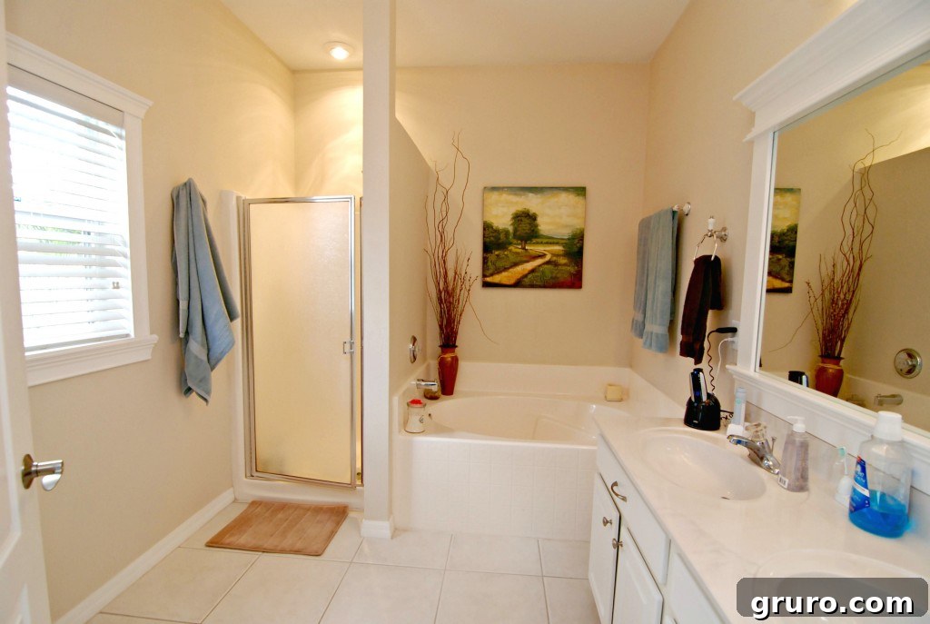Bright master bathroom featuring a framed window and a styled mirror