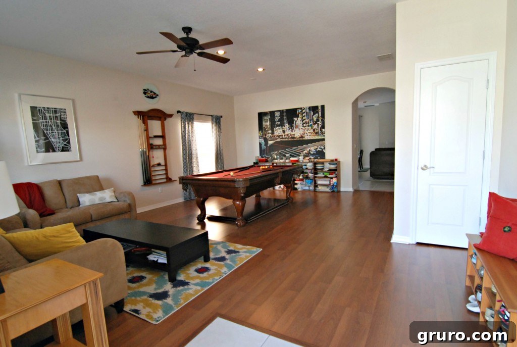 Spacious front room featuring a large pool table, enhancing its recreational appeal
