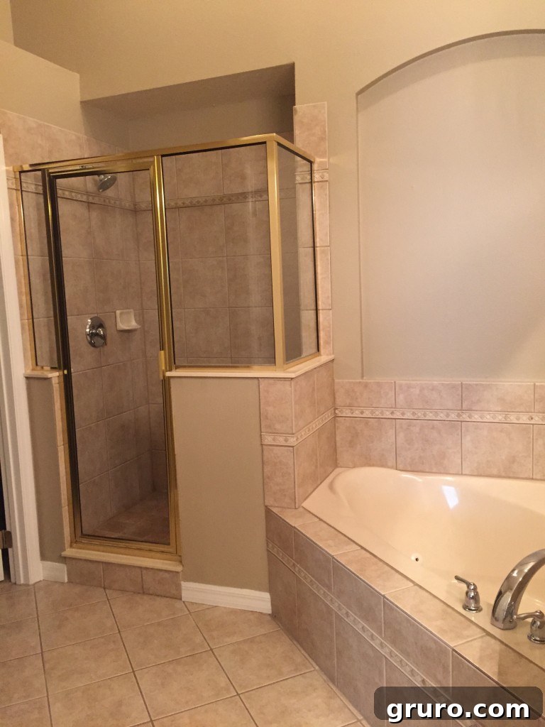 Master bathroom with gold-framed shower door and renovation plans
