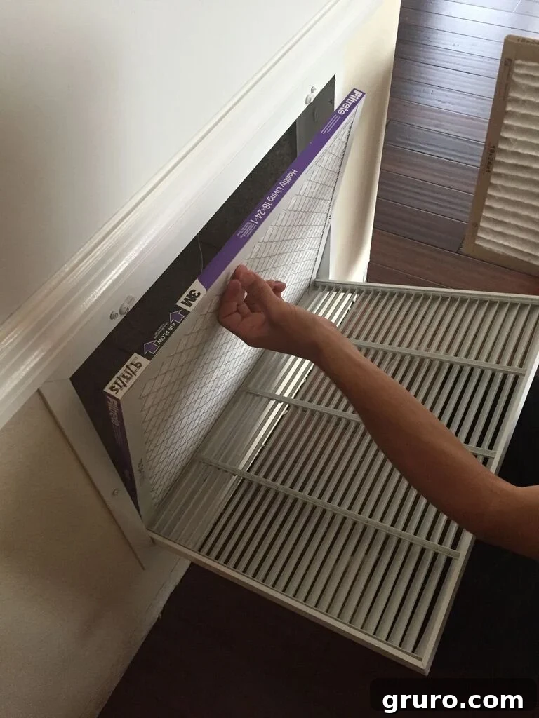 Young child helping install a new Filtrete air filter, learning about home maintenance from an early age