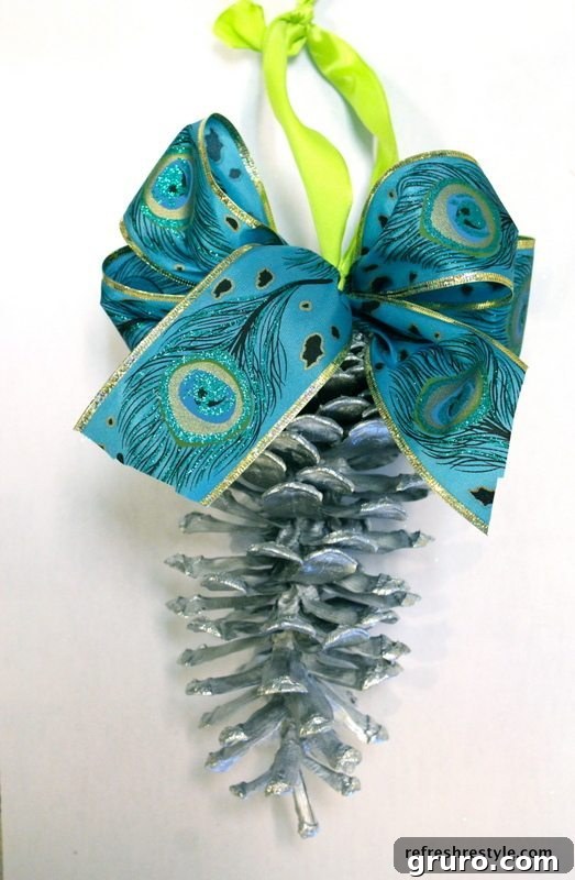 Hands tying a simple ribbon loop onto a pinecone for decorative hanging