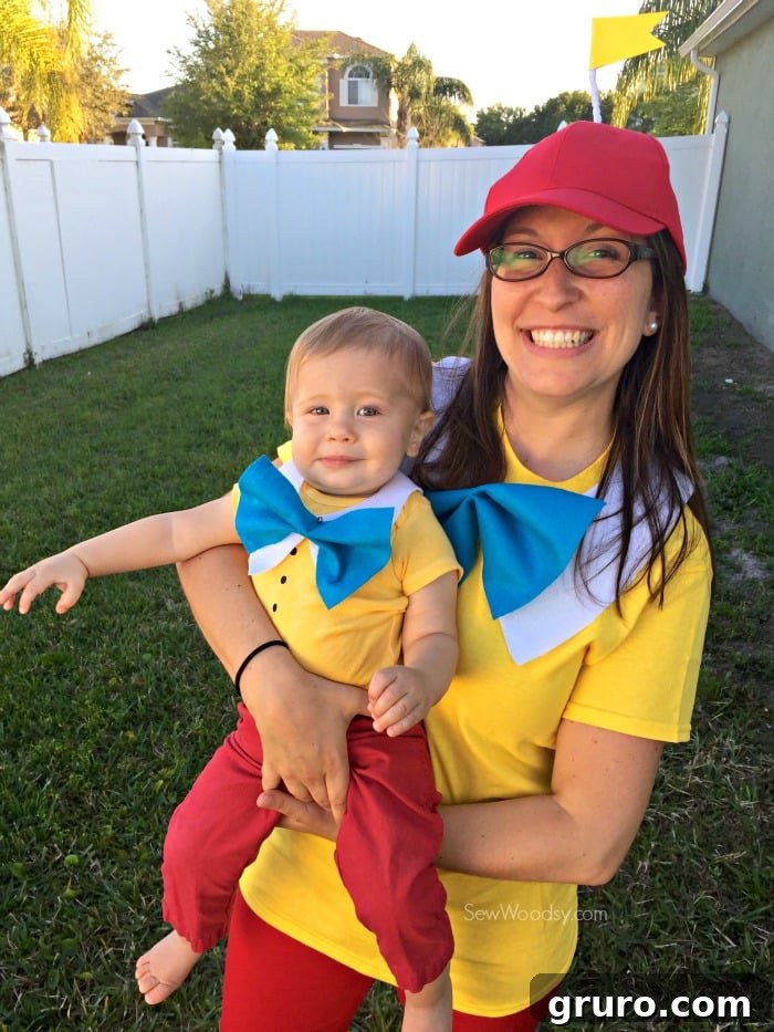 Effortless Tweedle Family Ensemble 8 Woman holding a baby boy, both dressed as Tweedledum and Tweedledee, smiling brightly.