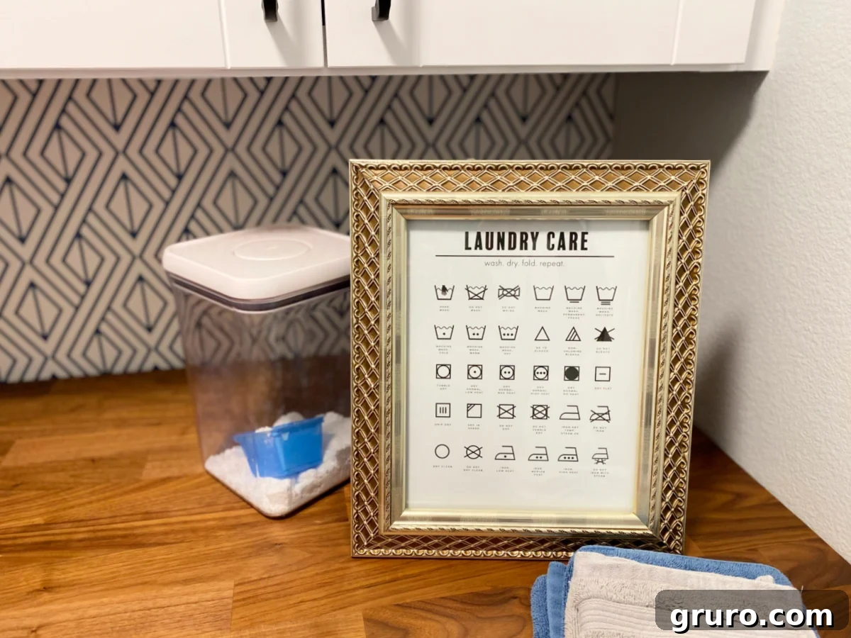 An elegant gold frame showcasing a "Laundry Care" sign with laundry symbols, beautifully displayed on a wooden countertop, offering a stylish and practical guide.