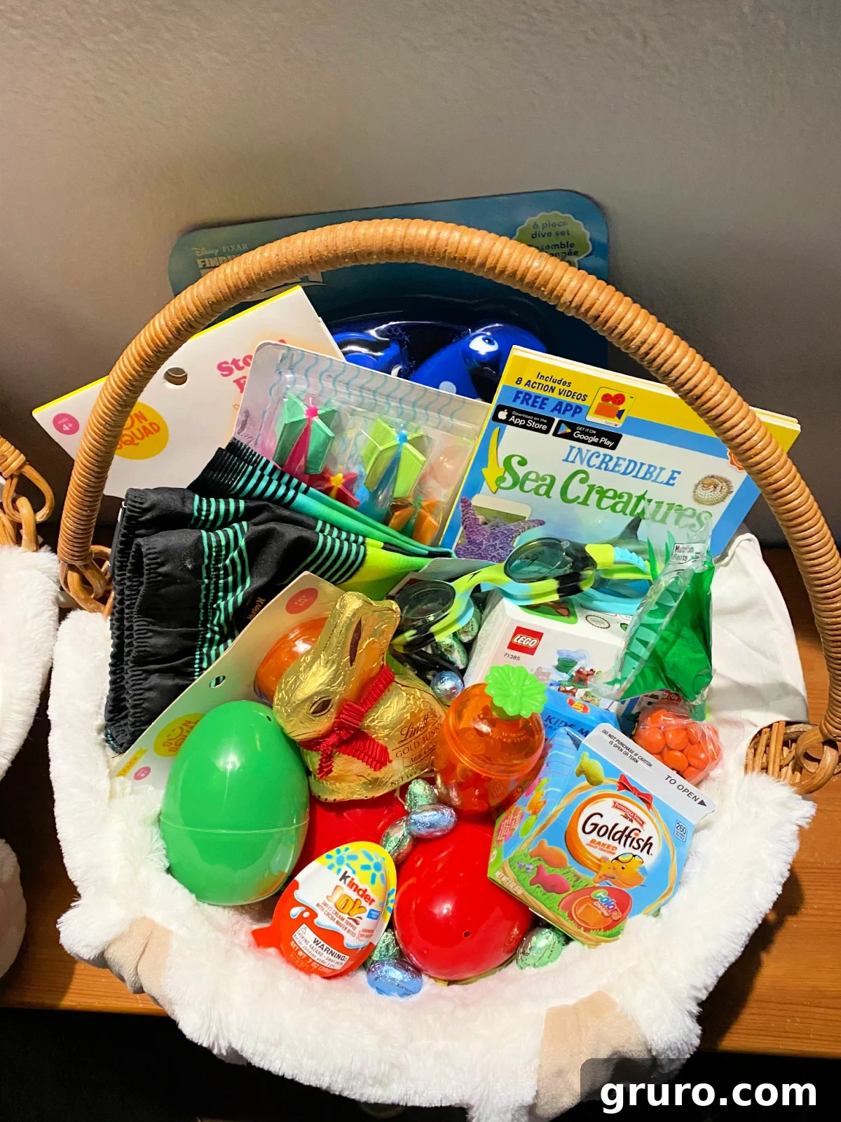 Magical Easter Basket Surprises for Youngsters 18 A boy's Easter basket filled with plastic eggs, a few candies, healthy snacks, a book, and water toys.