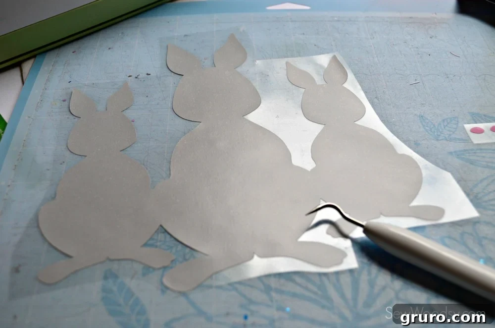 Weeding excess iron-on vinyl from intricate bunny design