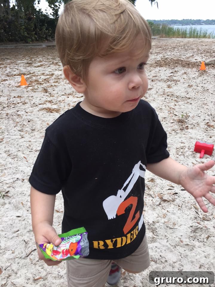 Close-up of Ryder in his 2nd Birthday Construction T-Shirt eating snacks