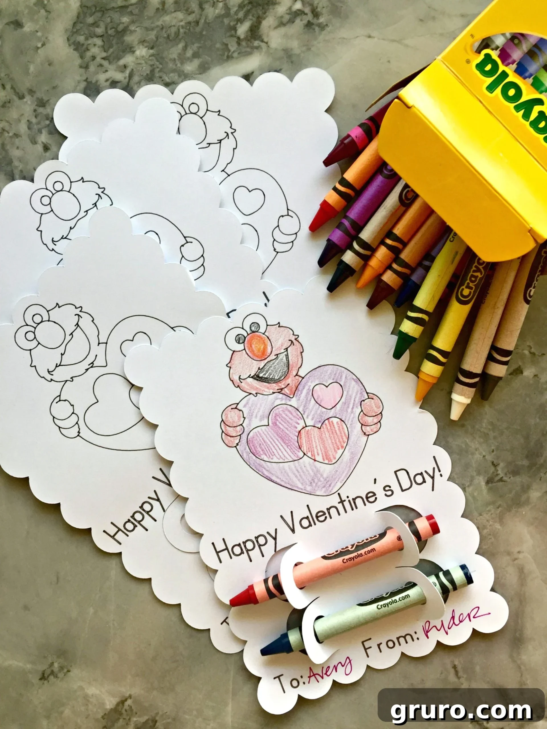 Elmo's Heartfelt Valentine 6 A delightful arrangement of multiple scalloped-edge Elmo coloring Valentines, each accompanied by a bundle of crayons, laid out on a clean counter.