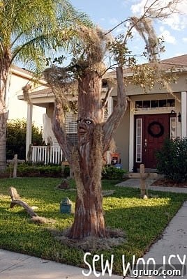 One of the spooky trees placed in a 'graveyard' setting as a Halloween decoration.