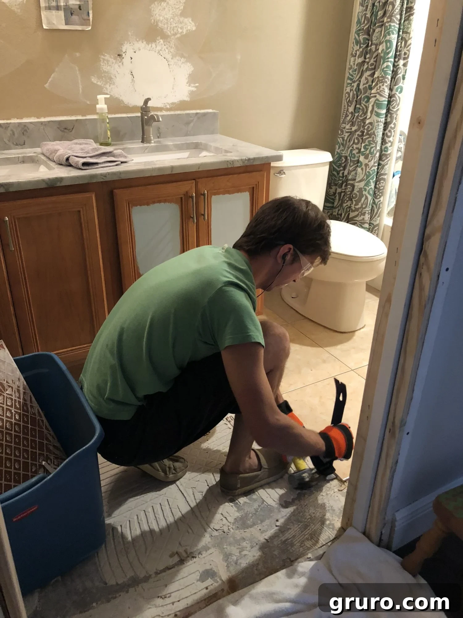 Jon starting the bathroom floor tile demolition