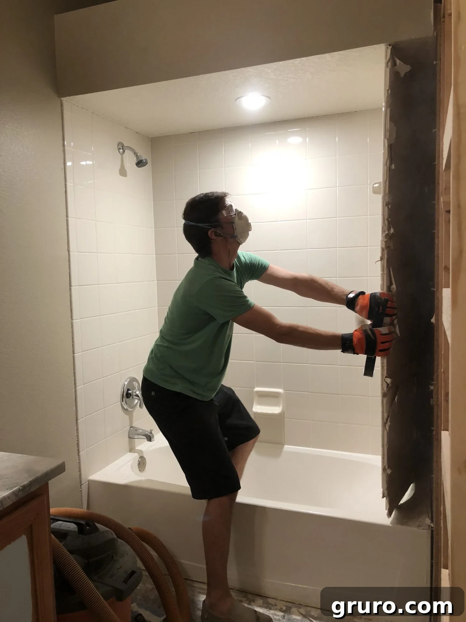 Jon meticulously removing shower wall tiles and hardy board