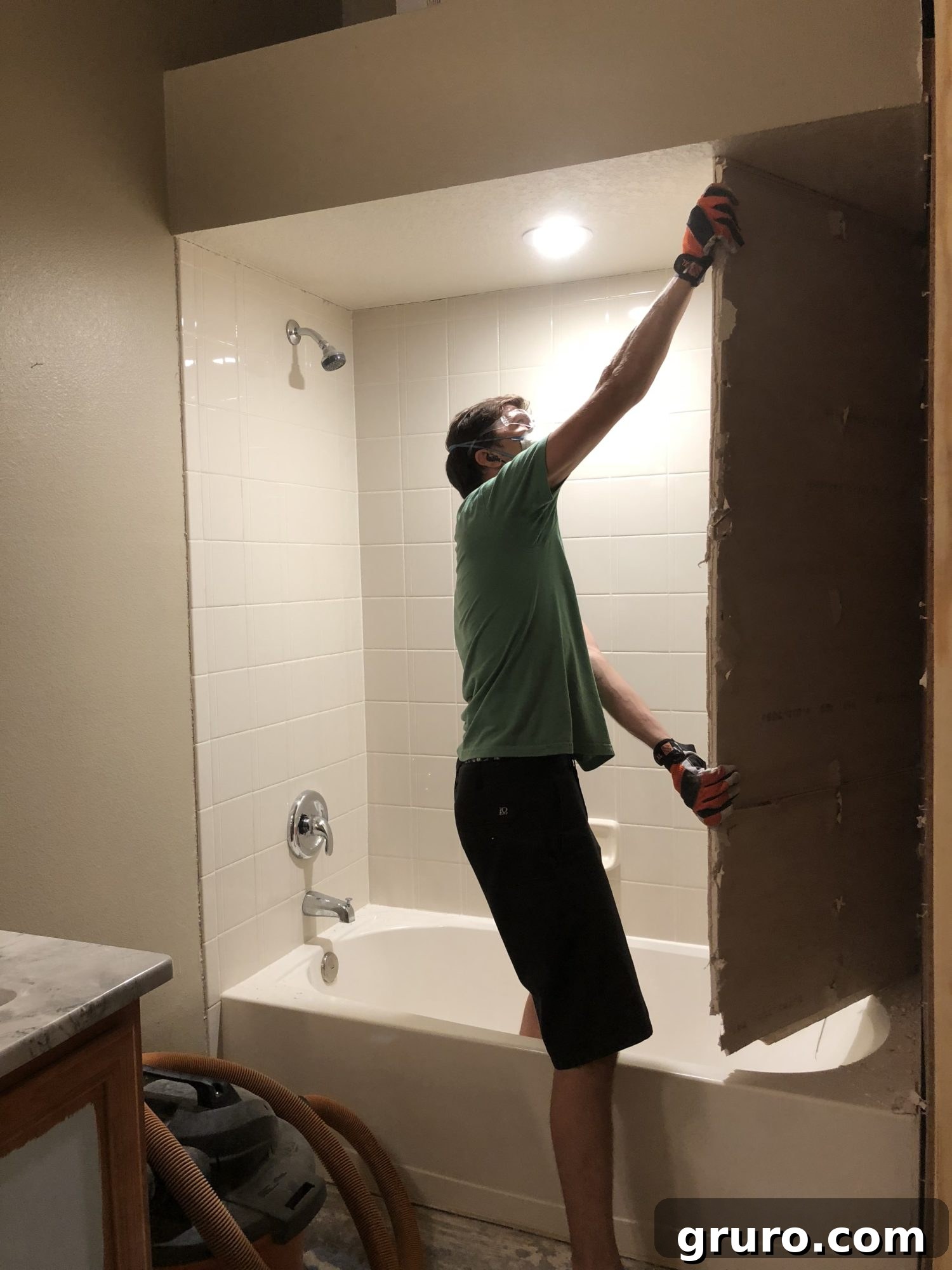Large sections of shower tile and hardy board being removed