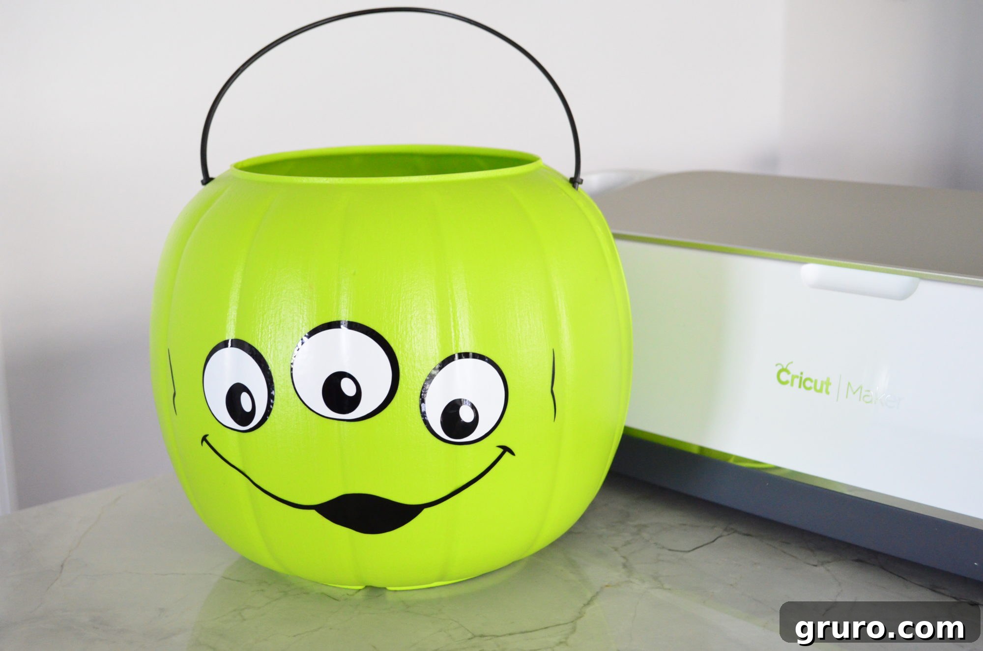 Completed Toy Story Alien Halloween Trick Or Treat Bucket with Cricut Maker in the background