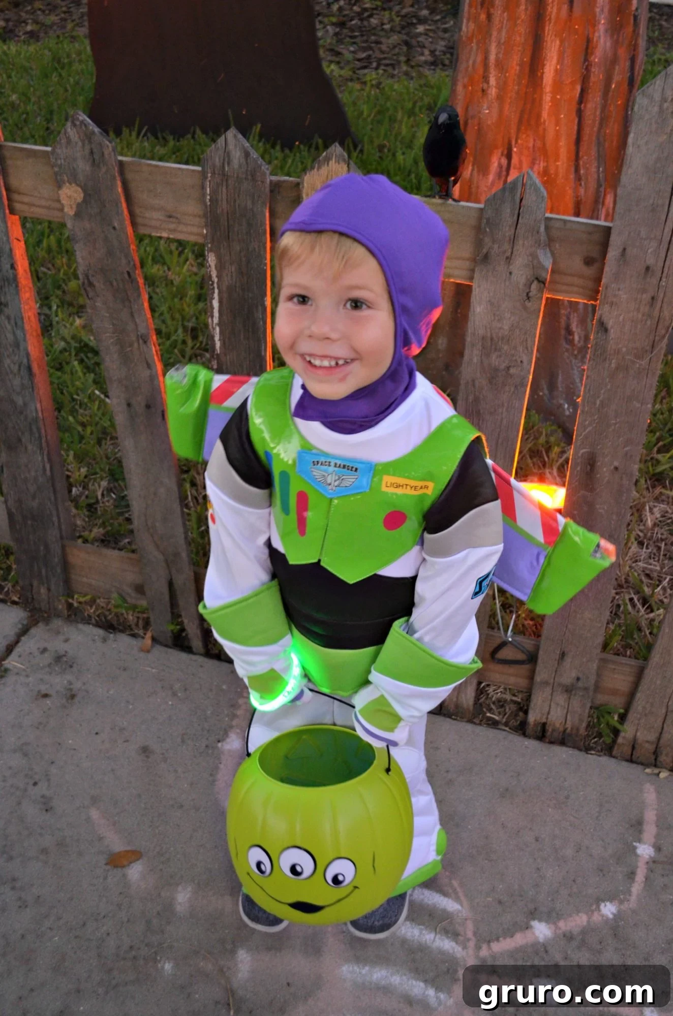 Young boy in Buzz Lightyear costume proudly holding his Alien Trick or Treat Bucket