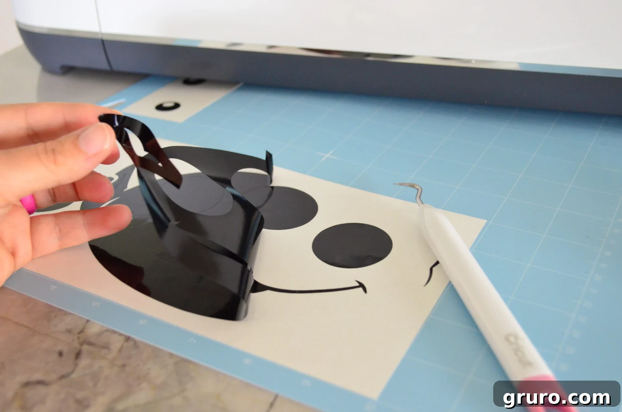 Carefully peeling the negative vinyl off, revealing the Alien's mouth and eye outlines