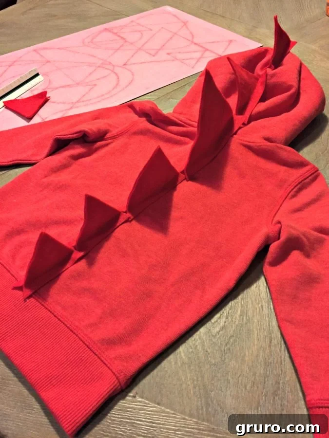 Dinosaur spikes glued onto the back of a sweatshirt